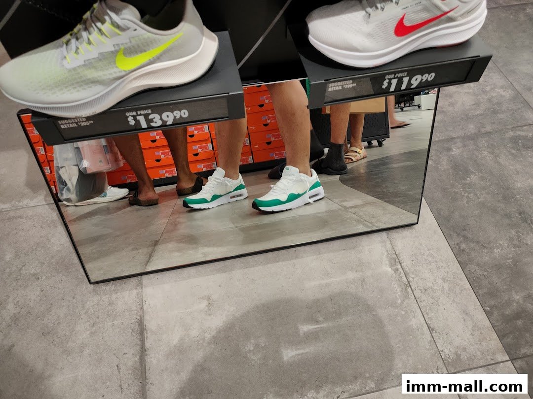 A mirror reflects shoes and price tags in a retail store with shoe boxes in the background.