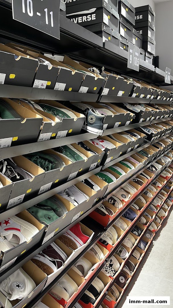 Rows of Converse shoe boxes neatly displayed on shelves, showcasing various styles and colors.
