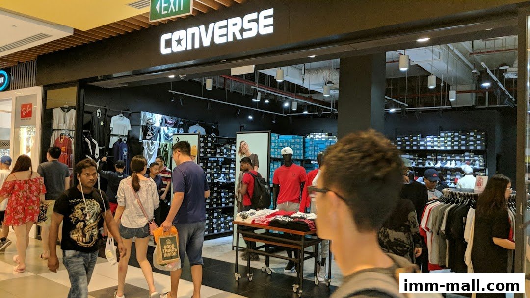 People browsing inside a Converse store, with shoes and apparel displayed.