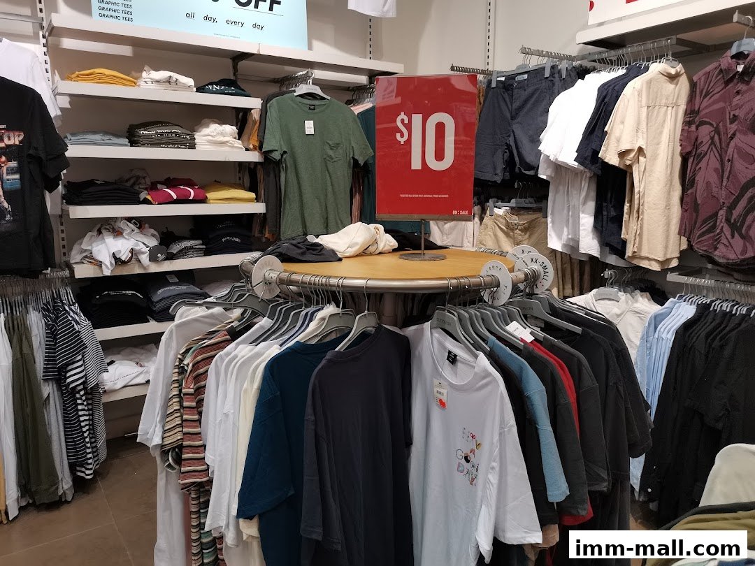 Interior view of a Cotton On store showcasing a variety of t-shirts and shorts on display racks and shelves.