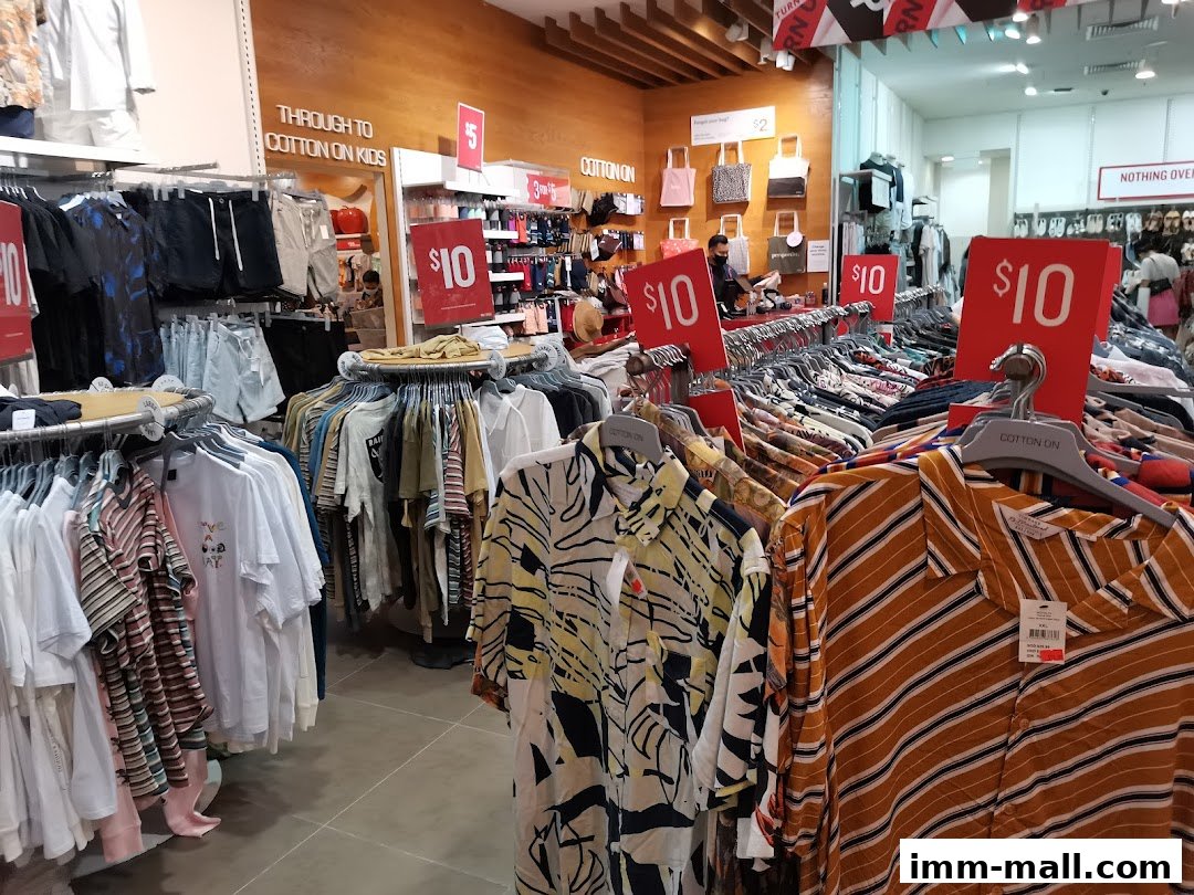 Interior view of a Cotton On store showcasing racks of clothing and promotional signs.