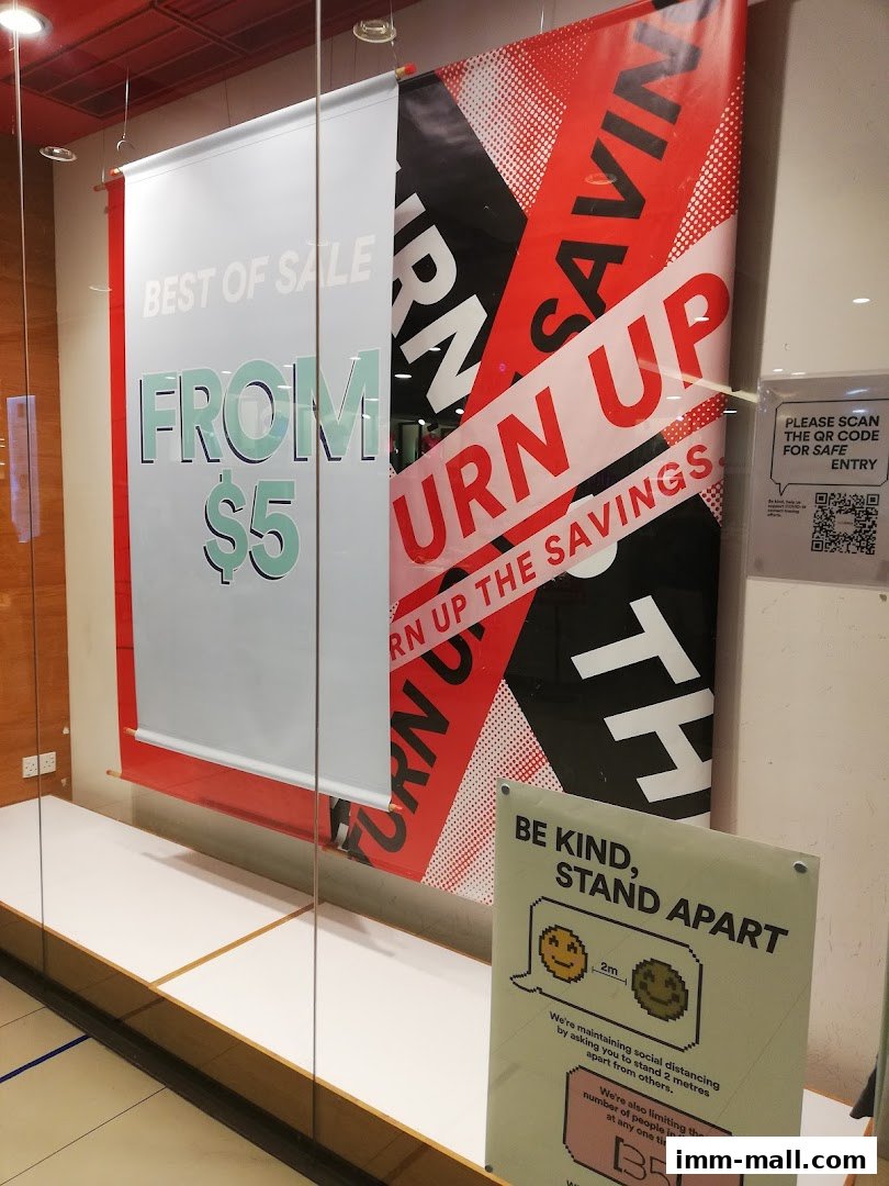 Shop window display with sale banners and social distancing signs.