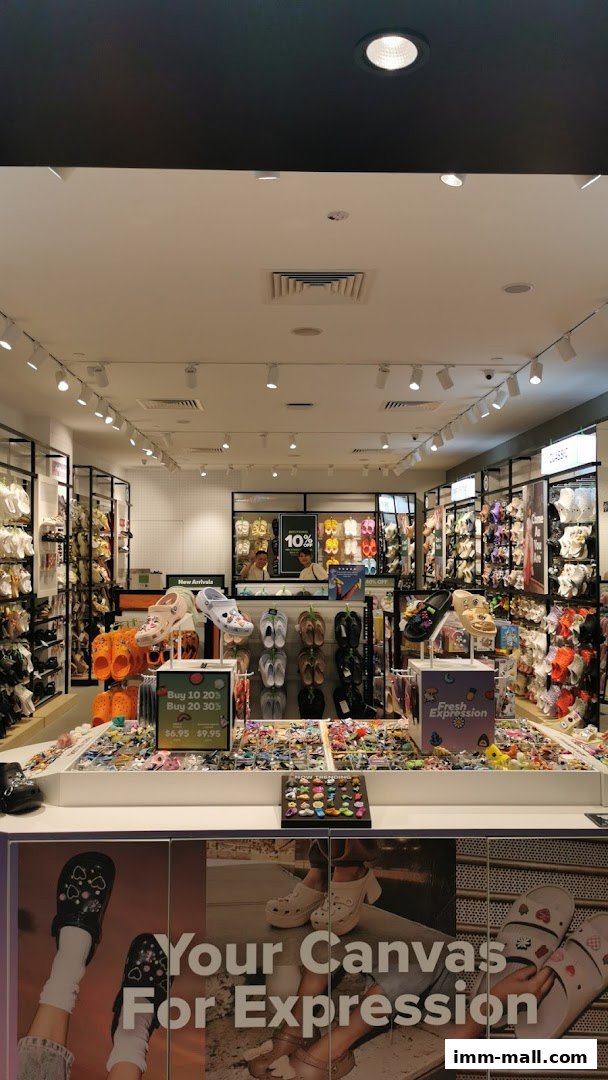 Interior view of a Crocs store showcasing a wide variety of colorful clogs and Jibbitz.