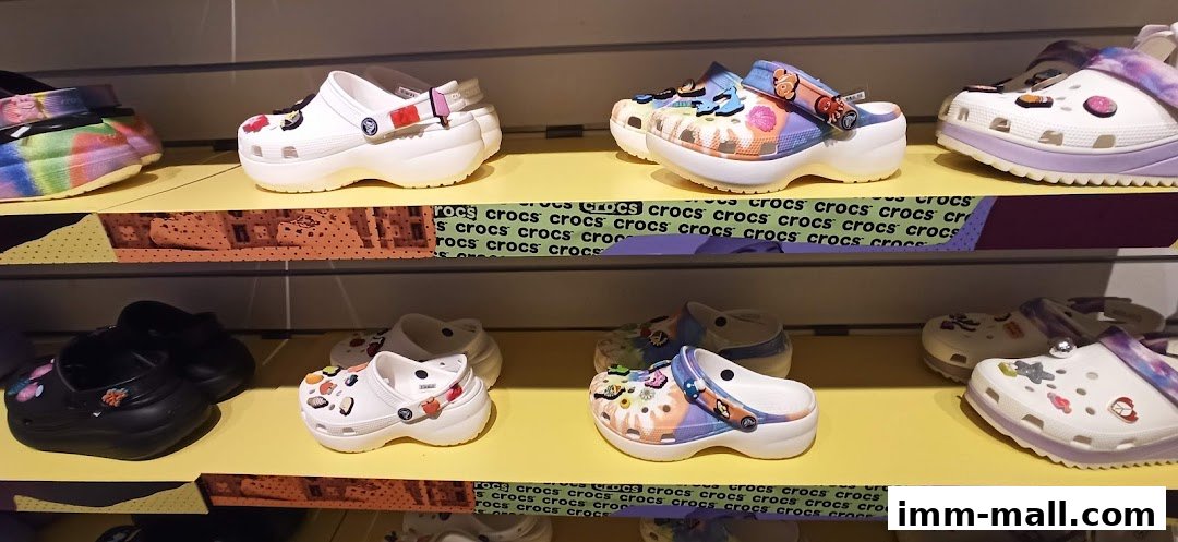 A display of colorful and decorated Crocs shoes on shelves.
