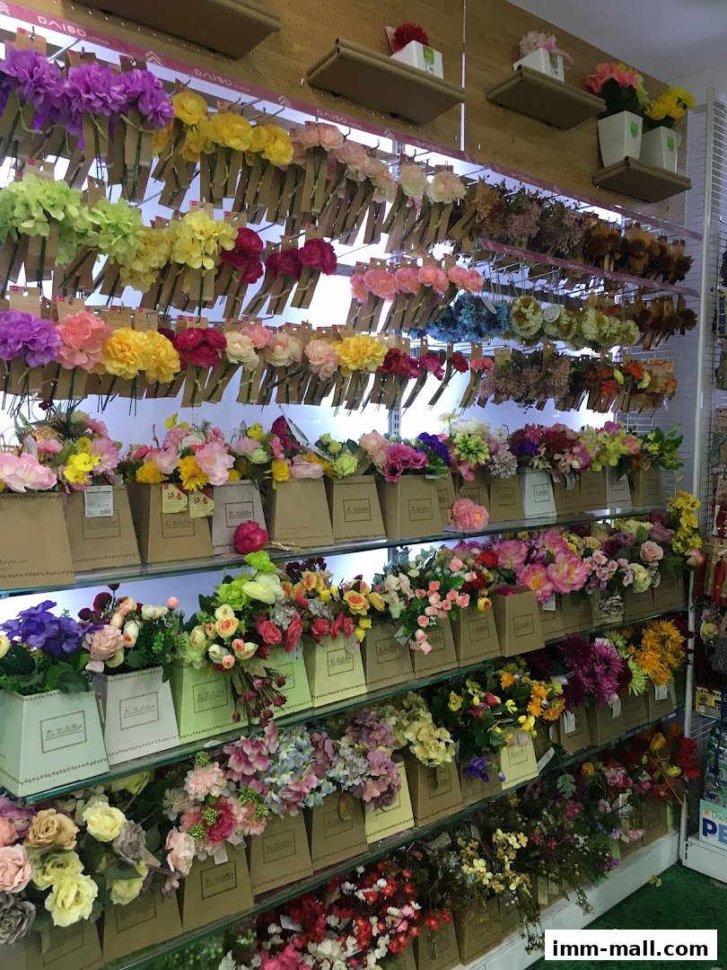 A wide selection of artificial flowers in various colors and arrangements displayed on shelves.