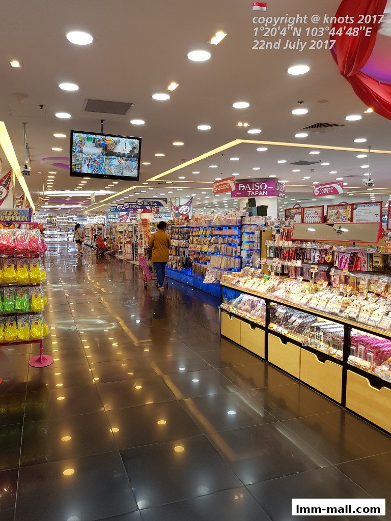 Interior view of a brightly lit retail store with aisles of merchandise and shoppers.