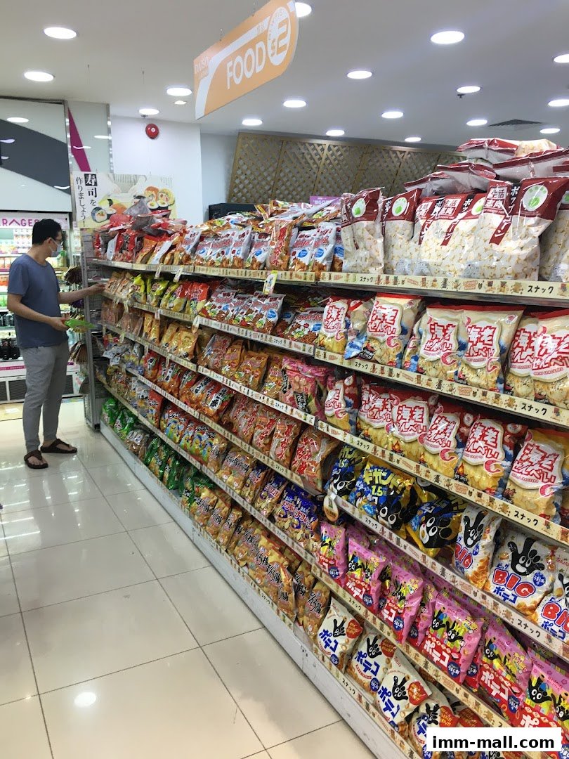 A customer browses shelves stocked with a wide variety of snacks at a Daiso store.