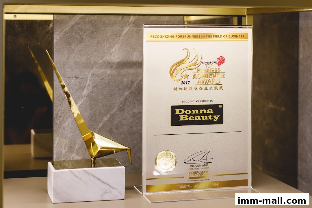 A gold award trophy and a framed certificate recognizing Donna Beauty as a Top Business Achiever.