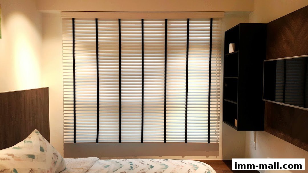 A bedroom interior with blinds, a shelf, and a television mounted on the wall.