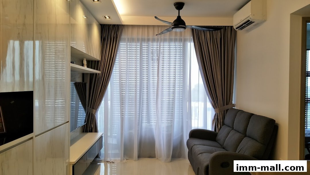 A modern living room with sleek cabinetry, a comfortable sofa, and large windows with curtains.