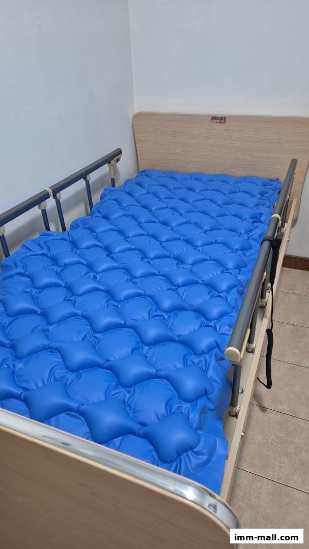 A hospital bed with a blue inflatable mattress and side rails.