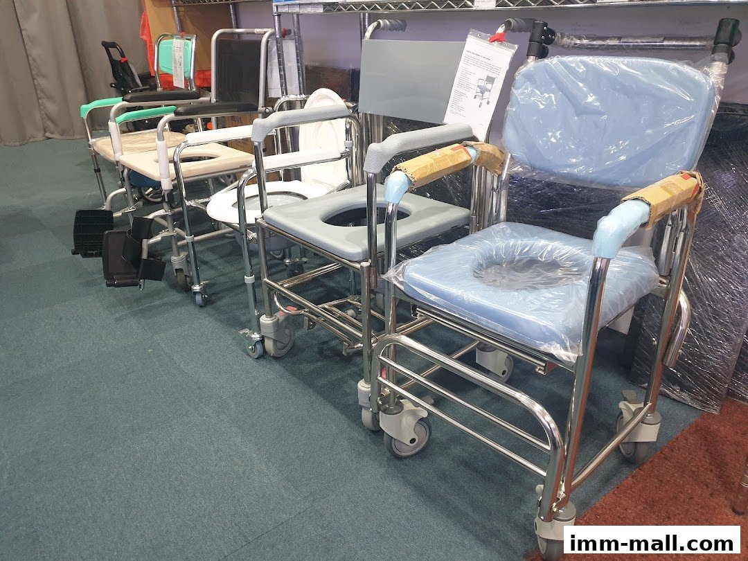 A row of various medical chairs, including commode chairs and wheelchairs, displayed indoors.