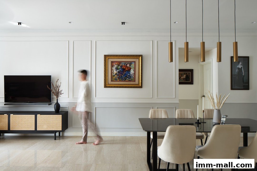 A modern living and dining area with a TV, artwork, and a dining table with chairs.