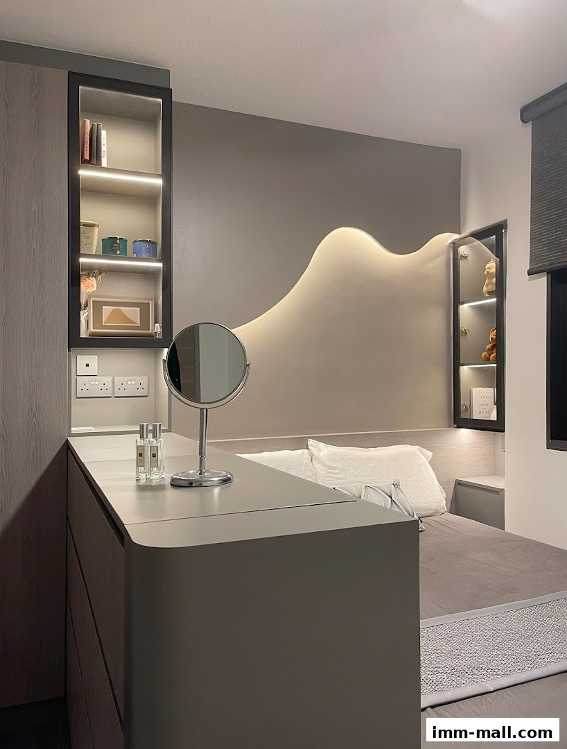 A modern bedroom interior with a stylish headboard, built-in shelves, and a vanity area.