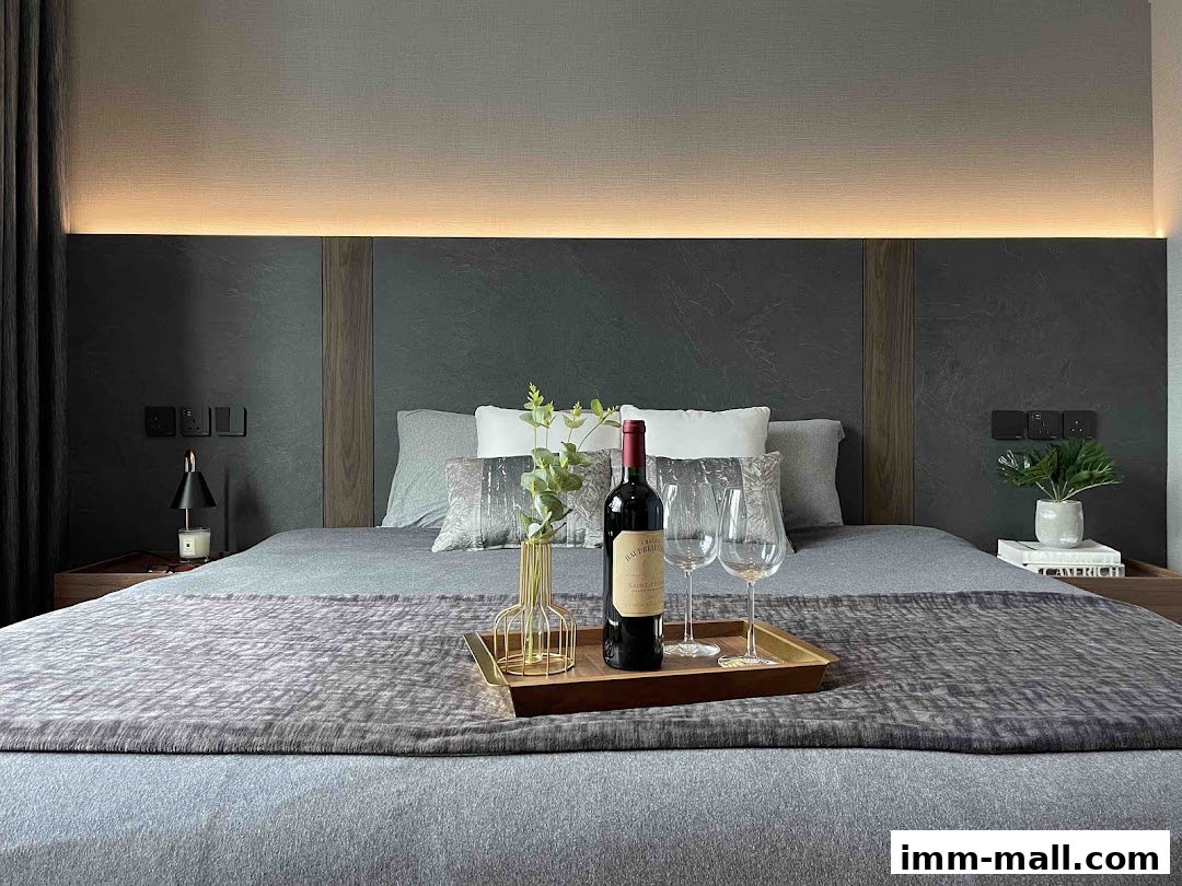 A modern bedroom with a bed, wine bottle, glasses, and decorative elements.
