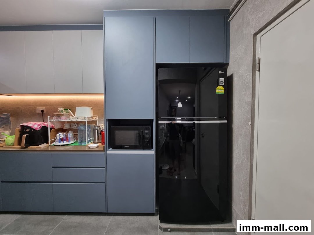 A modern kitchen with grey cabinets, a black refrigerator, and a microwave.