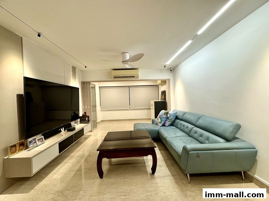 A modern living room with a large TV, sectional sofa, and coffee table.