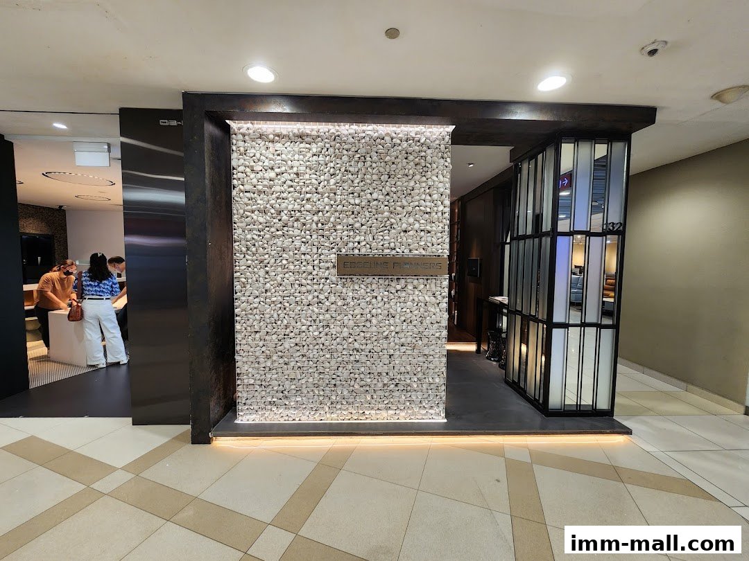 The entrance to Edgeline Planners IMM Mall, featuring a stone-clad wall and modern glass partitions.