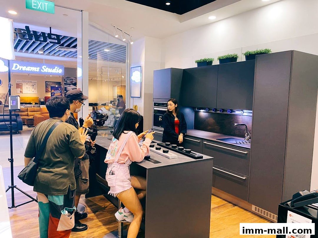 People filming a modern kitchen display in a store.