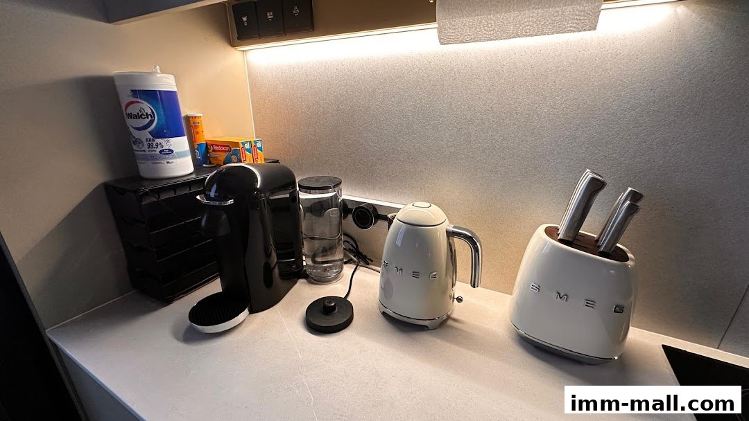 A kitchen counter with a coffee machine, kettle, and knife block.