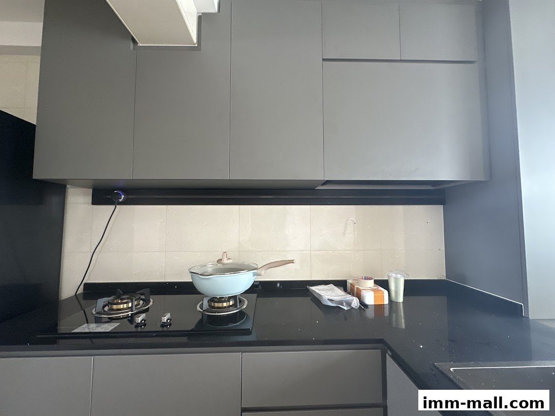 A modern kitchen counter with a stovetop, cabinets, and cooking utensils.
