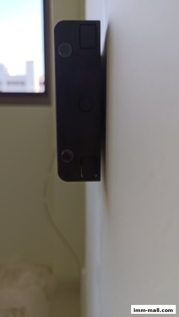 A close-up of a black Eubiq power track mounted on a light-colored wall.