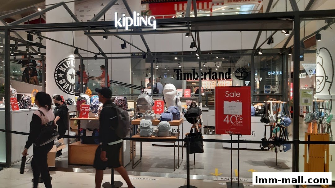 The Kipling store front displays various backpacks and bags, with a sale sign visible.
