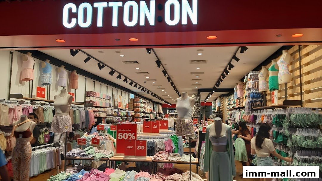 Interior view of a Cotton On store showcasing clothing on mannequins and racks, with sale signs visible.