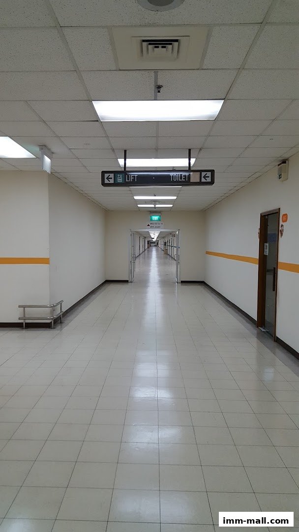 A long, well-lit corridor with signs pointing to the lift and toilet.