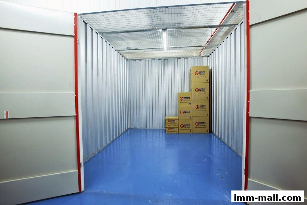 An empty self-storage unit with stacked boxes and an open door.