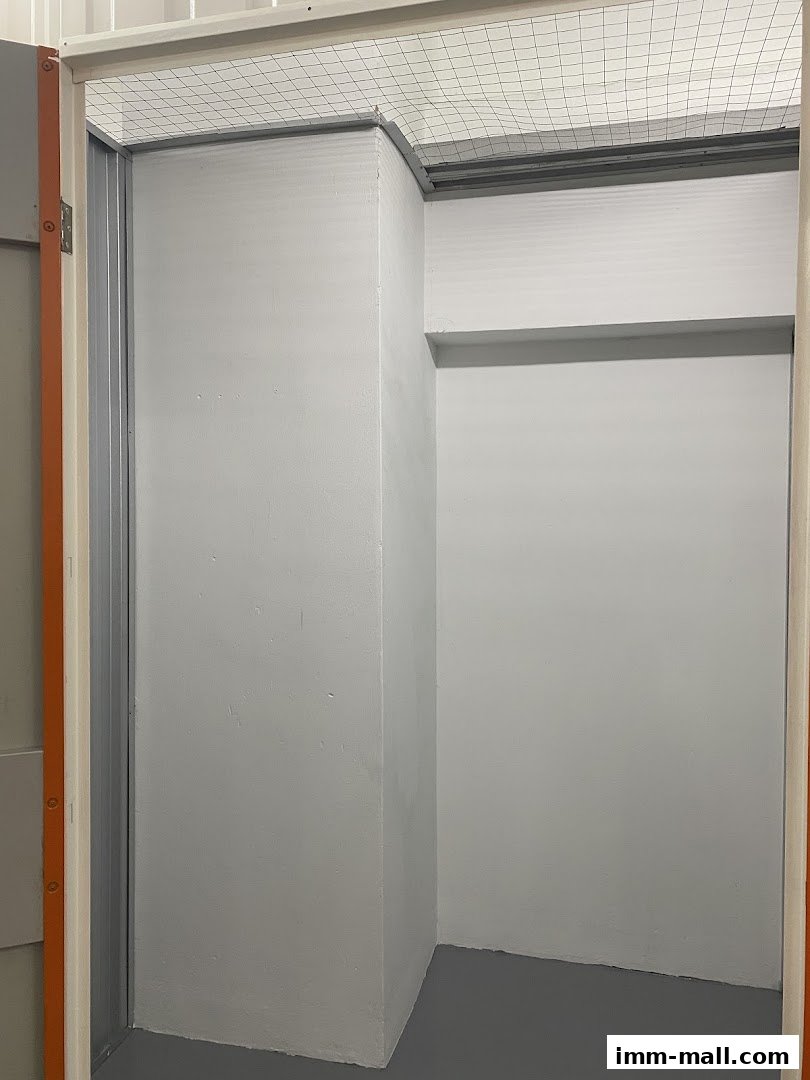 Interior view of an empty storage unit with grey walls and floor.