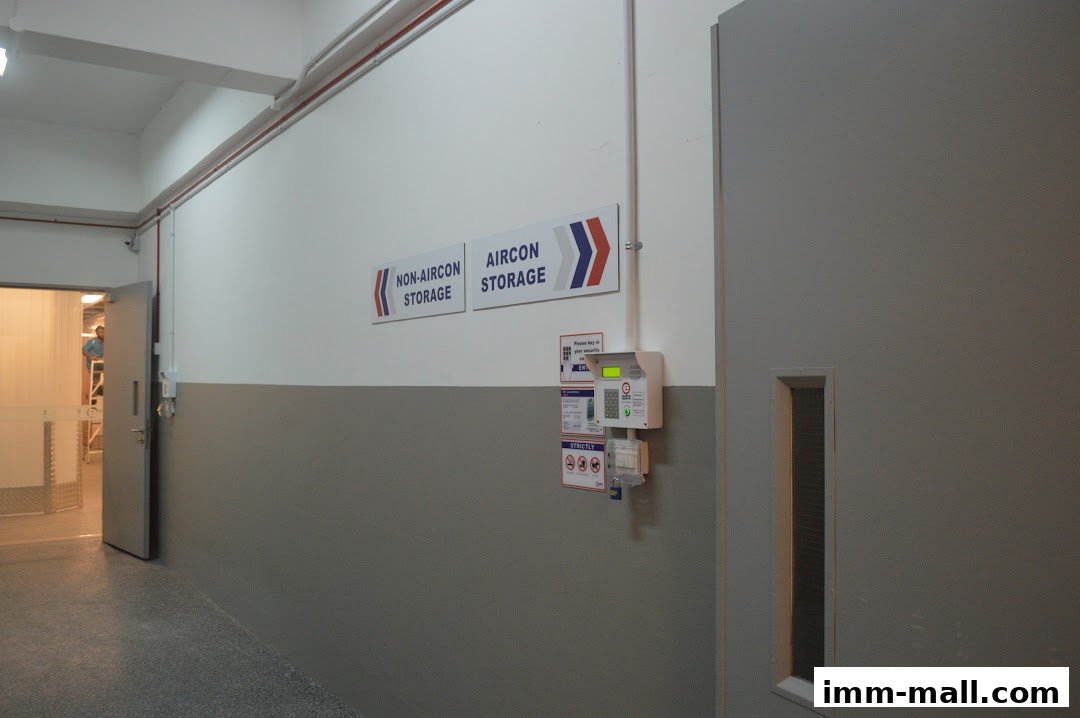 Hallway with signs for non-aircon and aircon storage, and a security access panel.