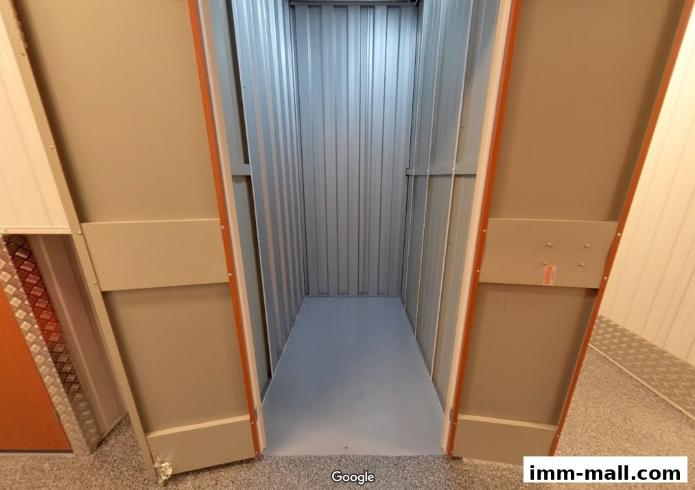 An empty, clean storage unit with metal walls and an open door.