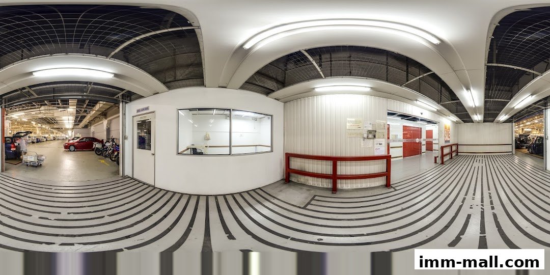 Interior view of a storage facility with parking bays, vehicles, and office areas.