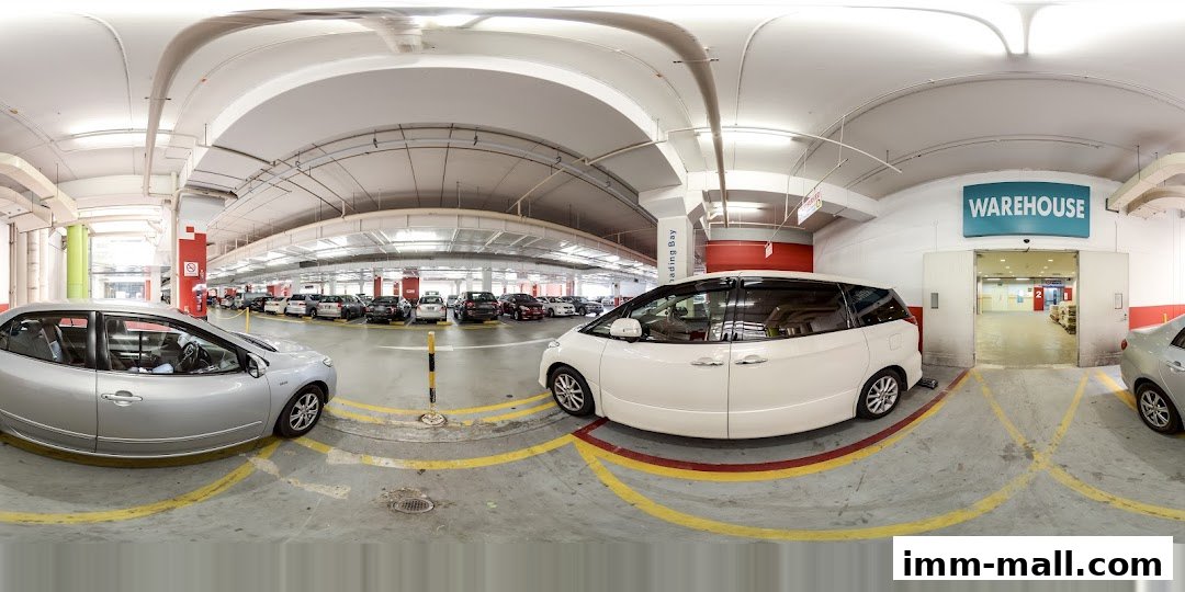 A parking garage with cars and a sign for a warehouse.