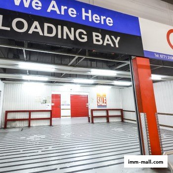 Interior view of a loading bay with red doors and a 'SALE' sign.