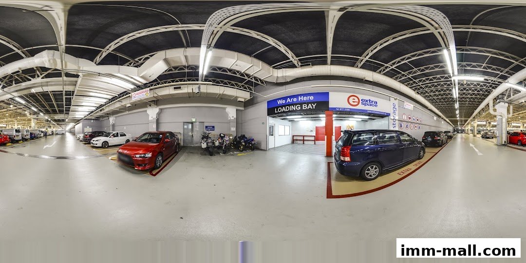 Interior view of a spacious, well-lit storage facility with cars and motorcycles parked.