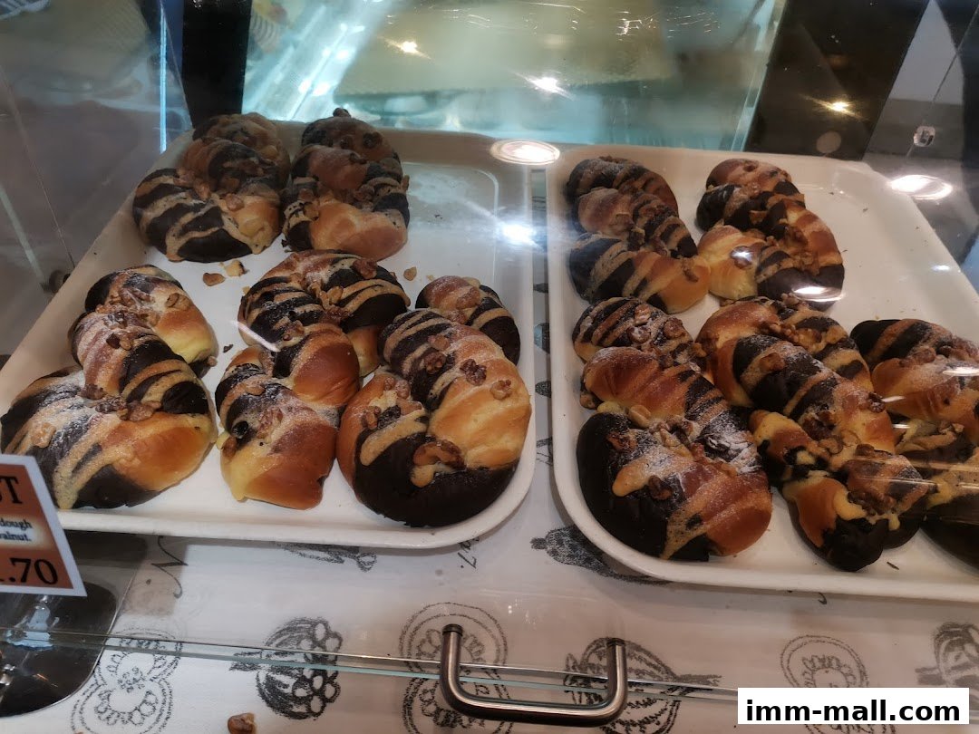 A display of freshly baked pastries with chocolate and walnut toppings.