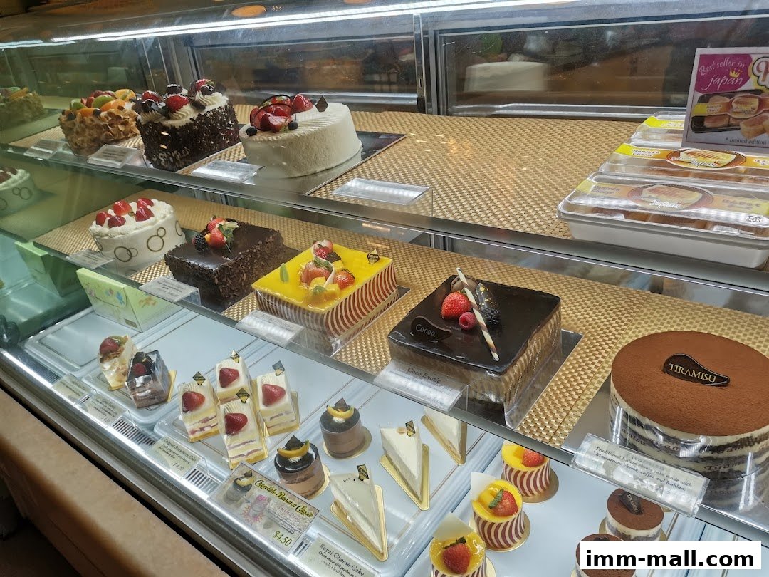 A display case filled with various beautifully decorated cakes and pastries.