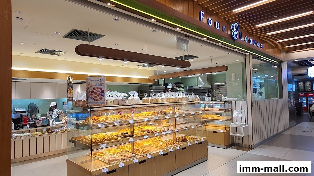 A bakery shop called Four Leaves displaying a wide variety of fresh baked goods in display cases.