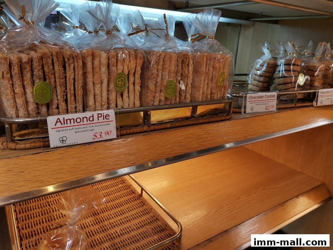 Packaged almond pies and chocolate cookies displayed on shelves at a bakery.
