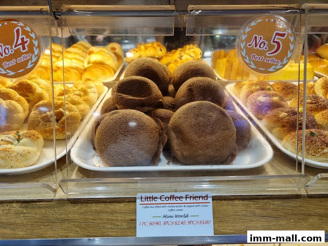 A display case filled with various freshly baked pastries and buns at a bakery.