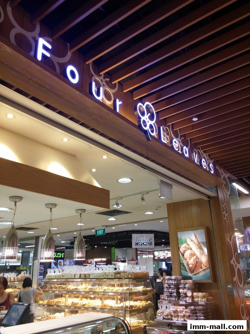 A bakery shop with a prominent 'Four Leaves' sign and display shelves filled with baked goods.