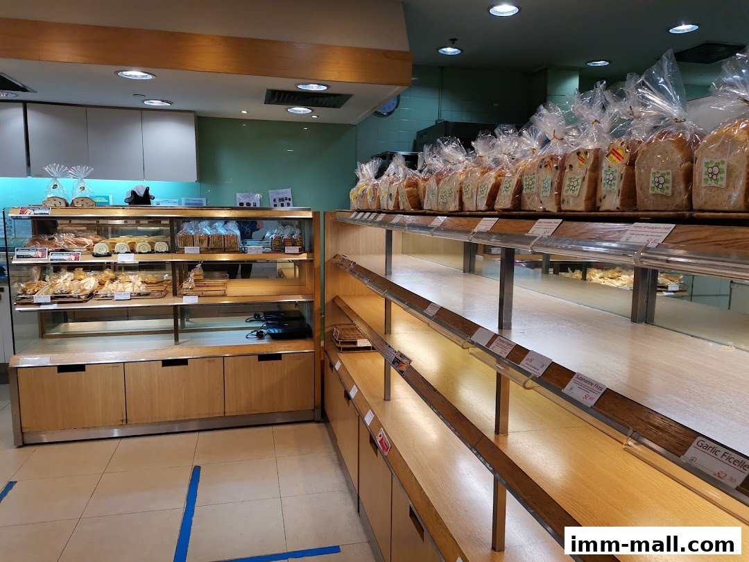 Interior view of a bakery with shelves displaying various breads and pastries.