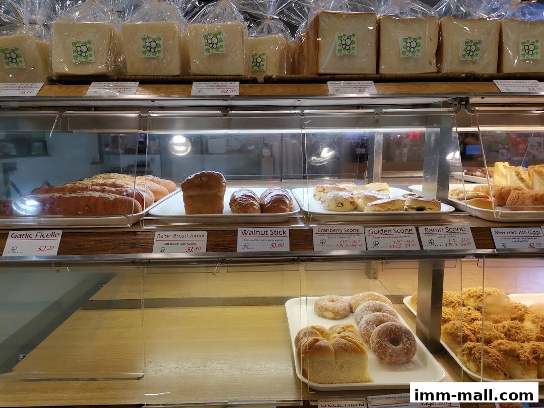 A display case filled with various baked goods including bread, scones, and donuts.