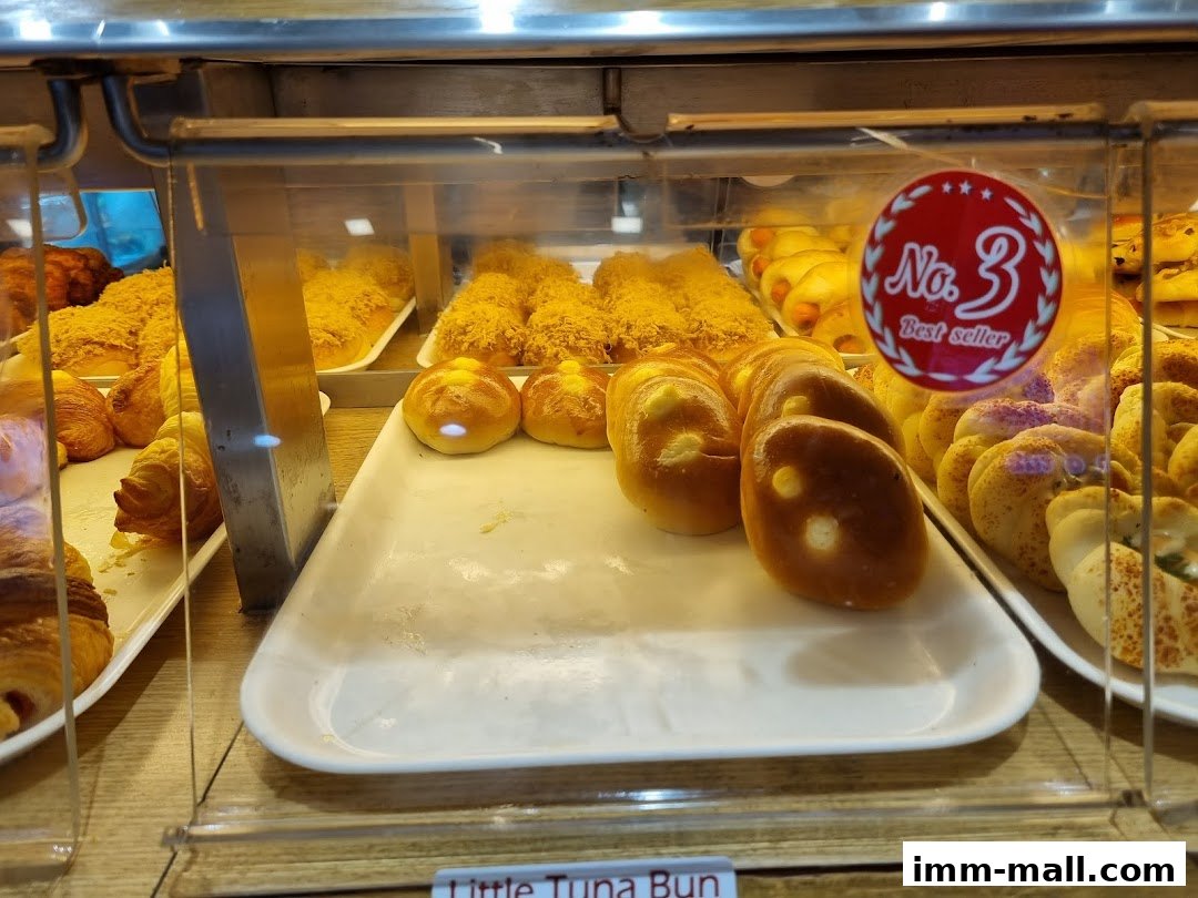A display case filled with various freshly baked pastries and buns from Four Leaves bakery.
