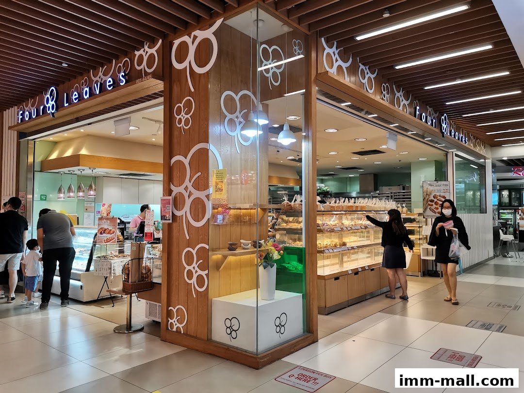 A bakery shop called Four Leaves with customers browsing its displayed baked goods.