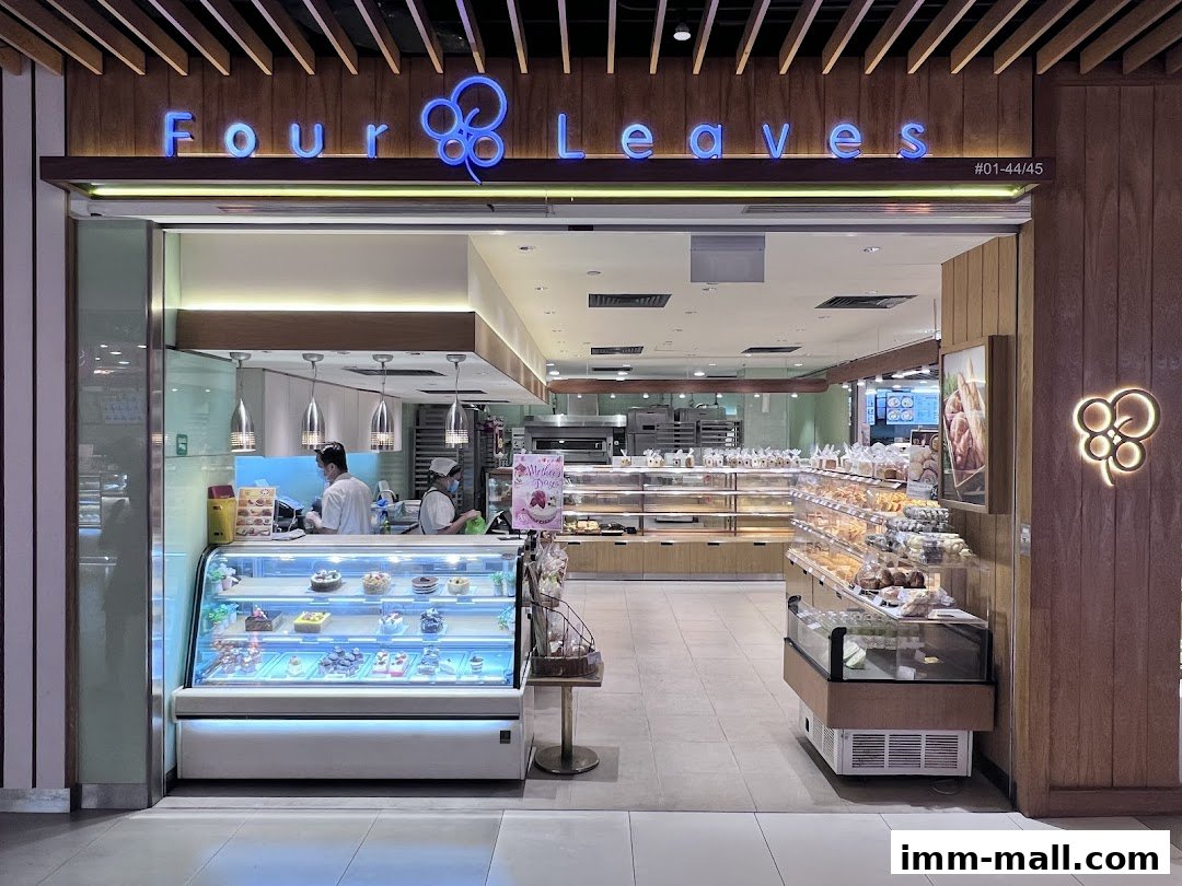 The Four Leaves bakery shop front displays cakes and pastries in refrigerated cases.