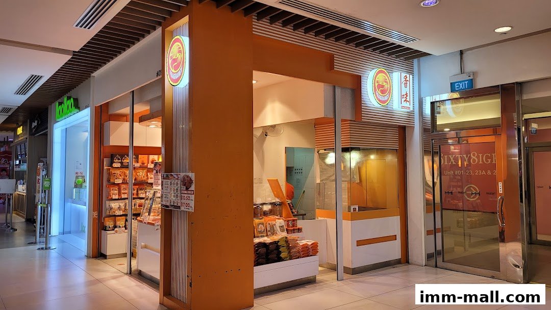 The exterior of a Fragrance Bakkwa shop with orange accents and products displayed inside.
