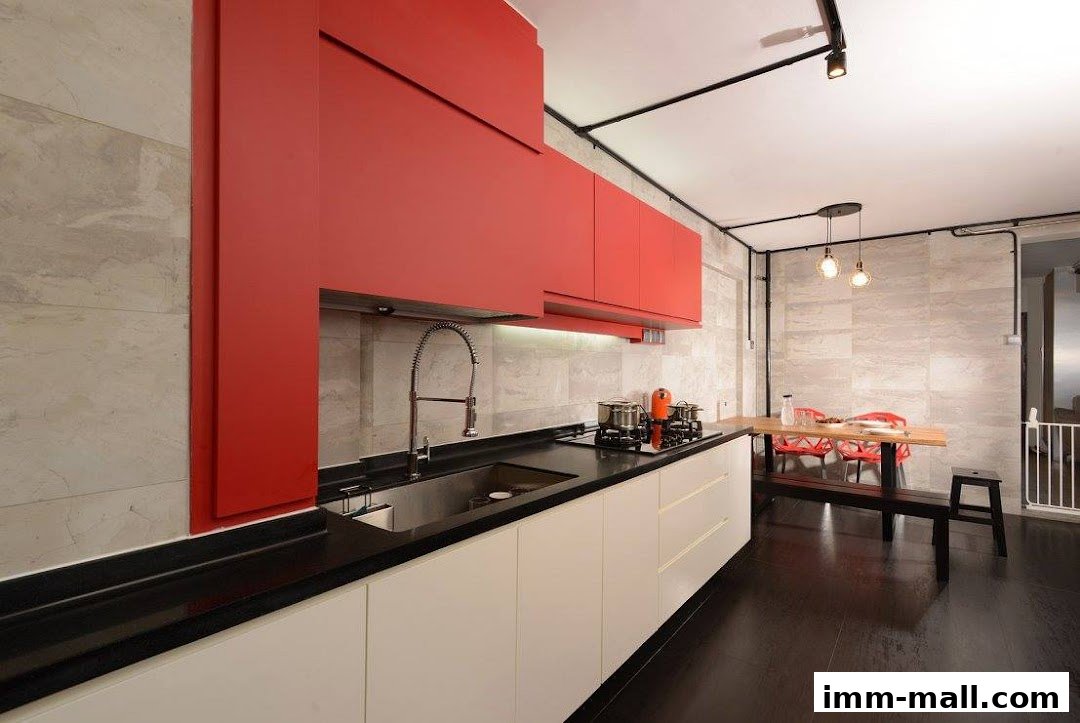 A modern kitchen with red and white cabinets, a stainless steel sink, and a dining area.